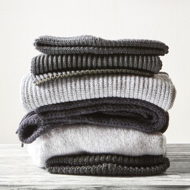 stack-gray-woolen-knitted-sweaters-white-surface_338799-2111